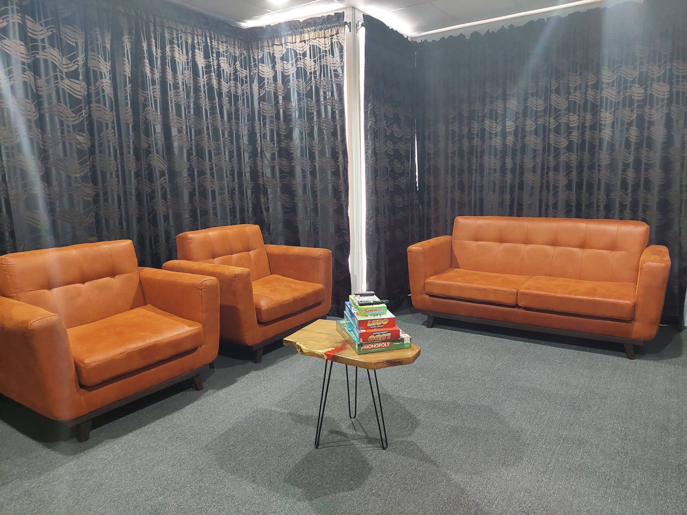 Lounge with tan leather sofas, a side table and patterned curtains